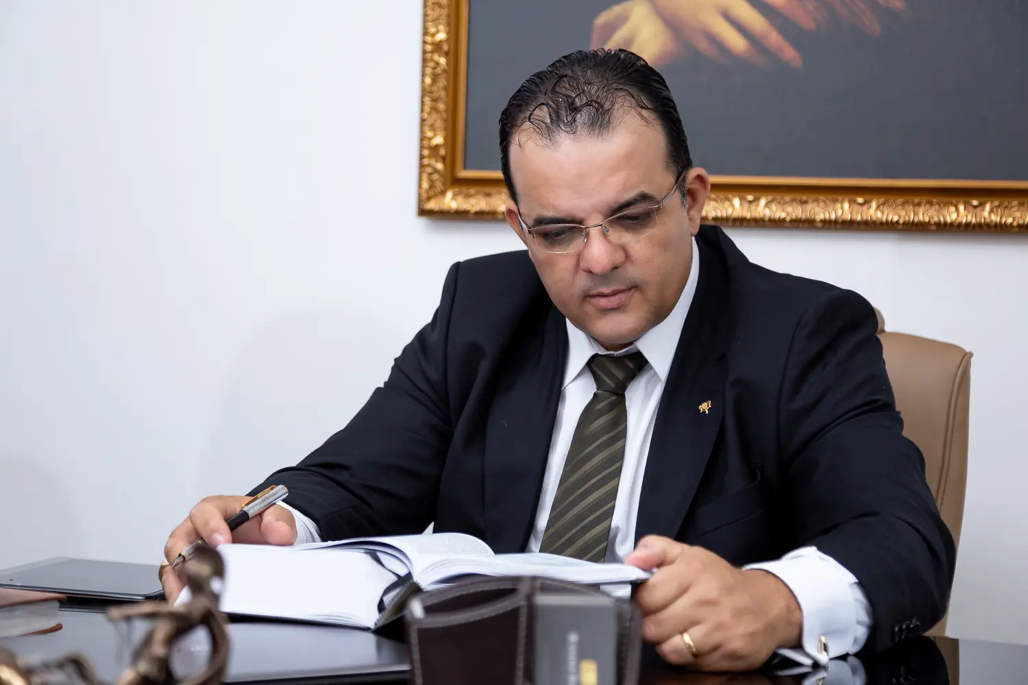 Wander Barbosa estudando documentos e literatura jurídica em seu escritório